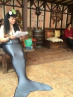 Vaquita (Victoria Ainsworth) reading The Drowner by Peadar O Guilin at Oberon's Traveling Tavern